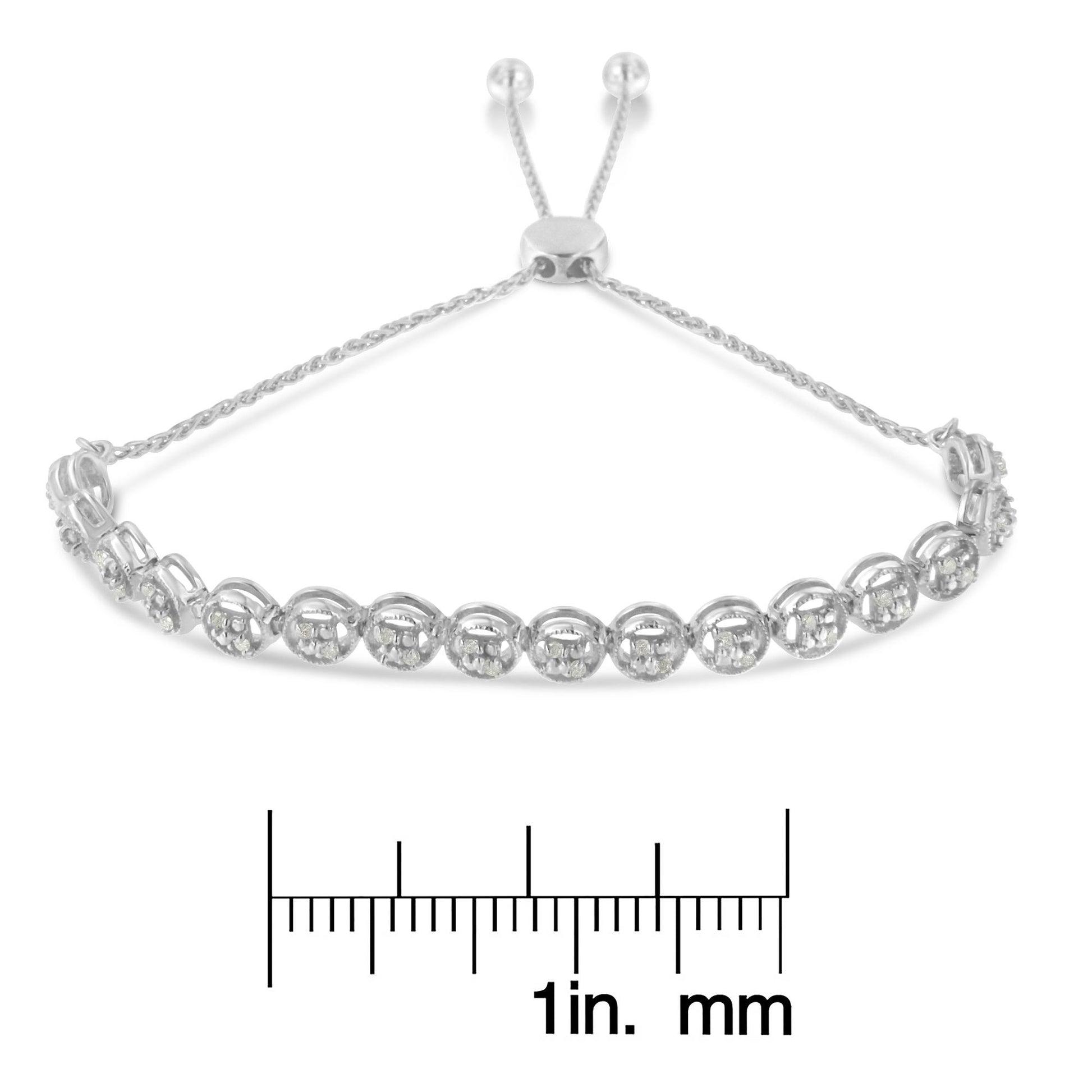 White metal bracelet with round white gemstones in prong settings, displayed flat with adjustable chain ends, shown above a ruler for size reference, angled front view.