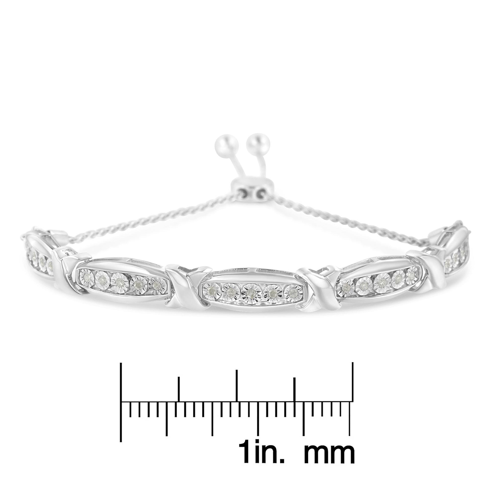 White metal bracelet with multiple sections set with round white gemstones in miracle setting, photographed from front on with a ruler below for size reference.