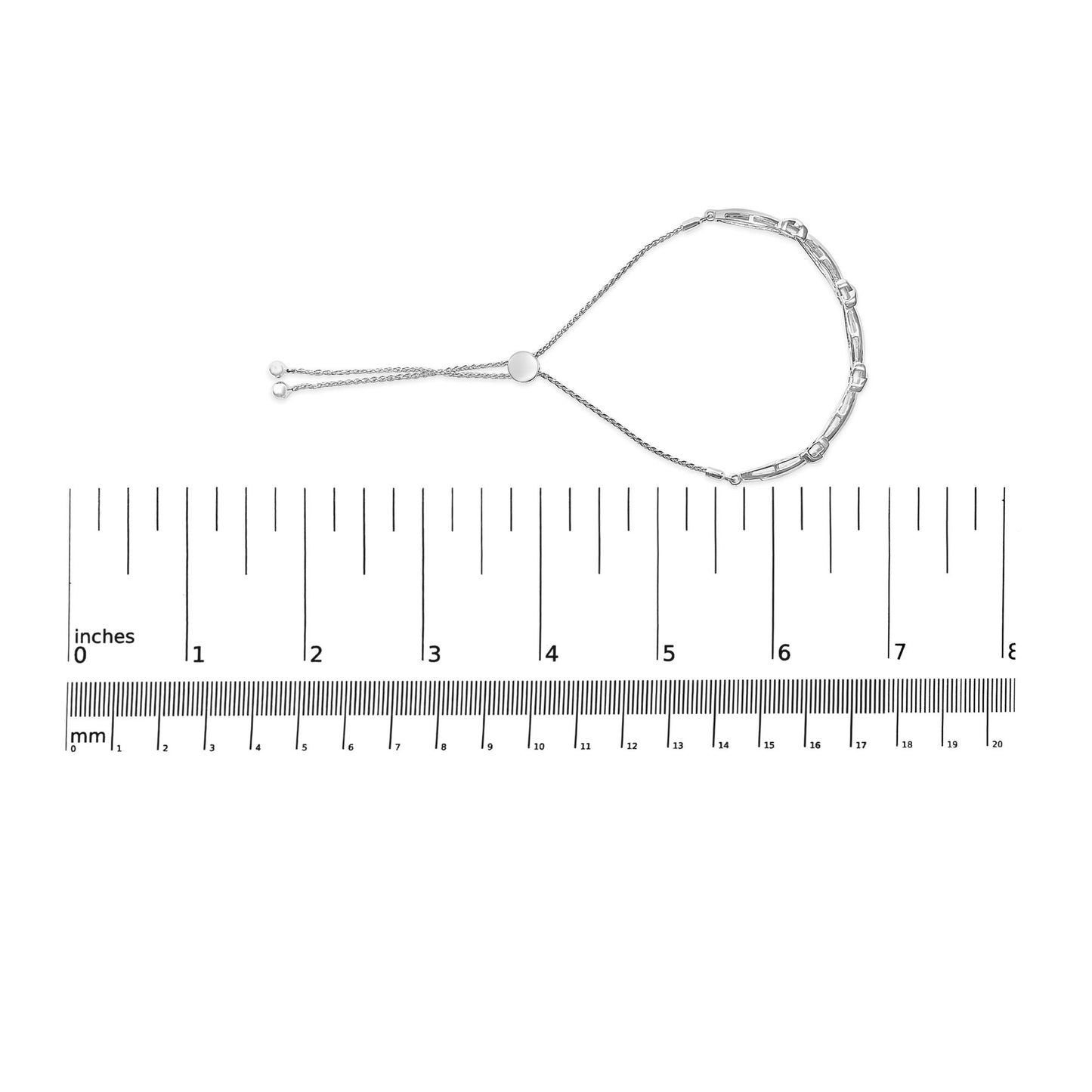 White metal bracelet with round white gemstones in miracle setting, shown flat on a ruler for size reference, top-down angle.