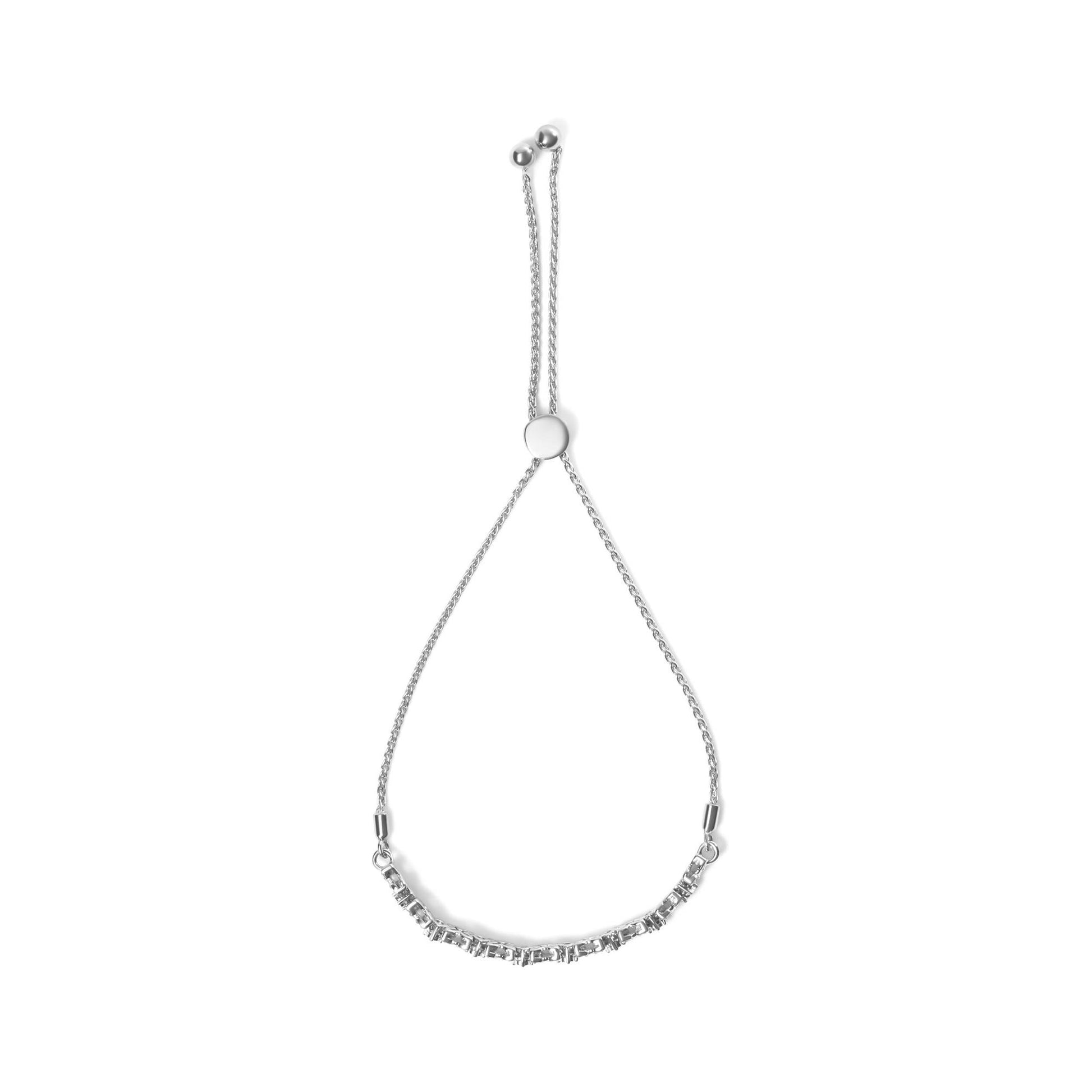 Top-down view of a white metal bracelet with a sliding clasp and two chains ending in small round beads, featuring a row of round white gemstones set in prong and miracle settings along the front.