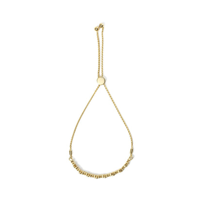 Top-down view of a yellow metal bracelet with a sliding clasp, featuring round white gemstones in prong and miracle settings along the lower section.