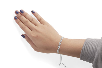 Close-up side view of a white metal bracelet with rectangular links adorned with round white gemstones in prong settings, worn on a model's wrist.
