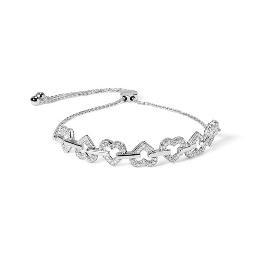 White metal bracelet with alternating heart and clover-shaped links set with round white gemstones, shown at a slight angle.