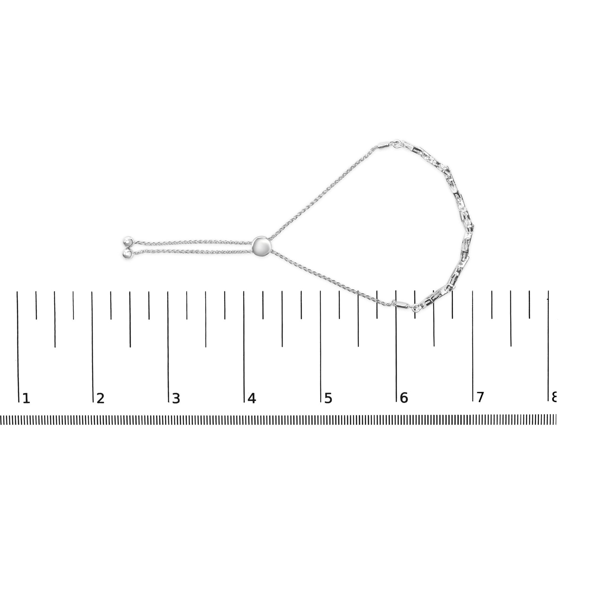 White metal bracelet with white gemstones in prong settings, shown flat on a ruler for size reference, top-down view.