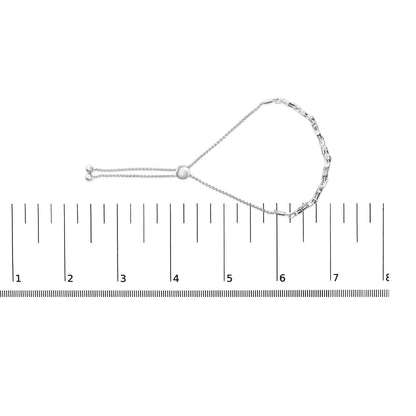 White metal bracelet with white gemstones in prong settings, shown flat on a ruler for size reference, top-down view.