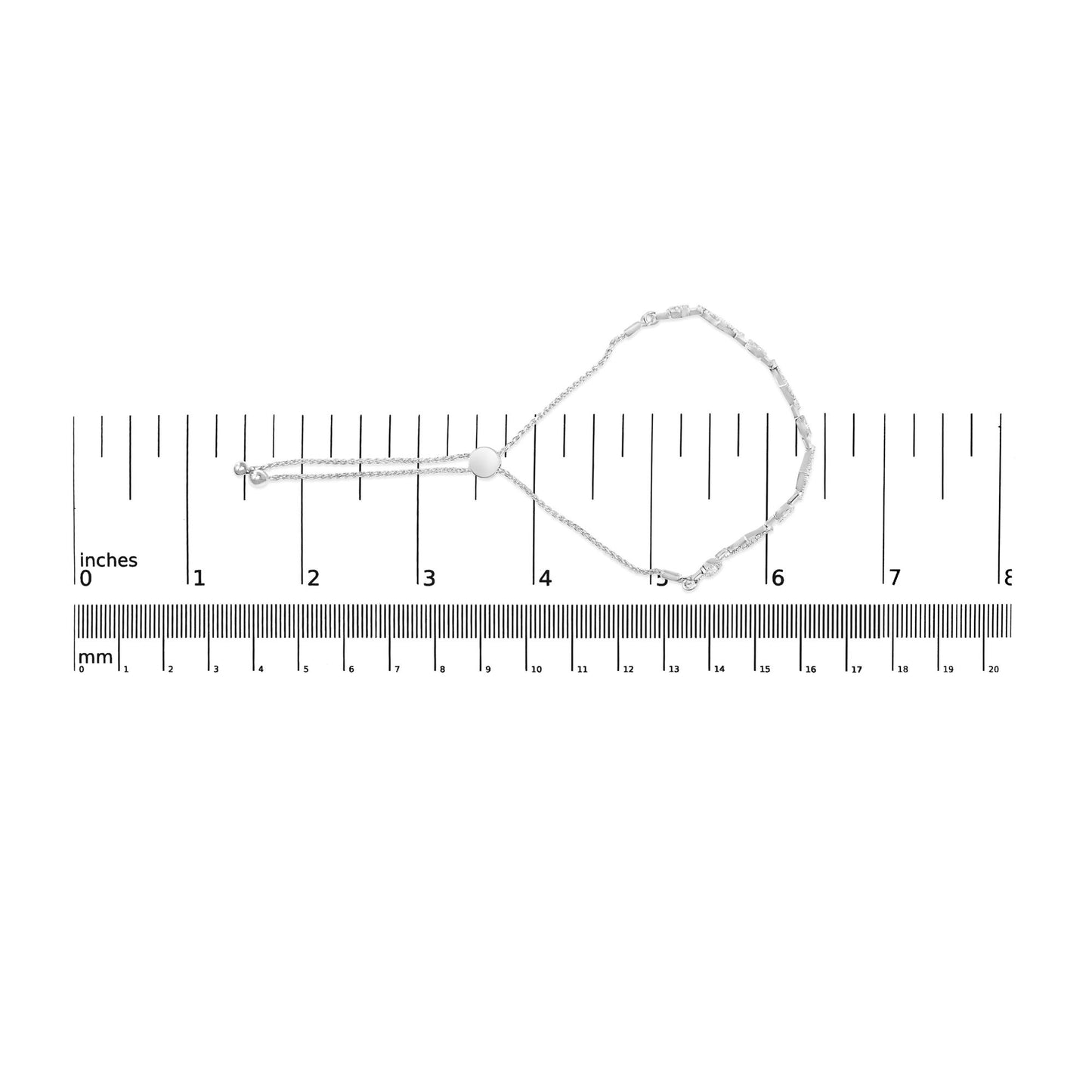 White metal bracelet with round white gemstones in prong settings, laid flat on a ruler for size reference, top-down view.
