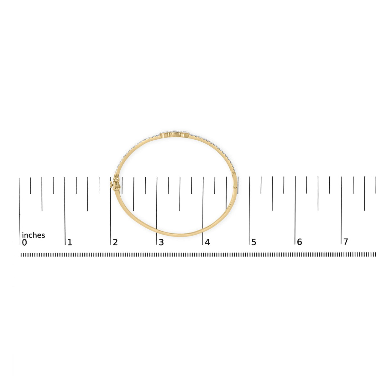 Yellow metal bracelet with round white gemstones in prong settings, shown on a scale from a top-down angle.