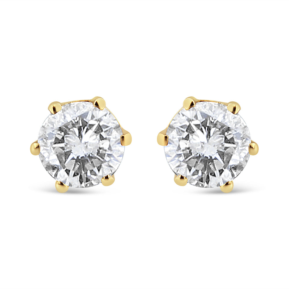 Front angle view of yellow metal stud earrings with round white gemstones in prong settings.