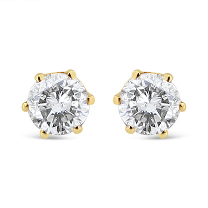 Front angle view of yellow metal stud earrings with round white gemstones in prong settings.