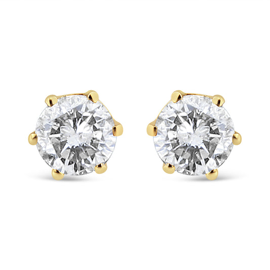 Front angle view of yellow metal stud earrings with round white gemstones in prong settings.