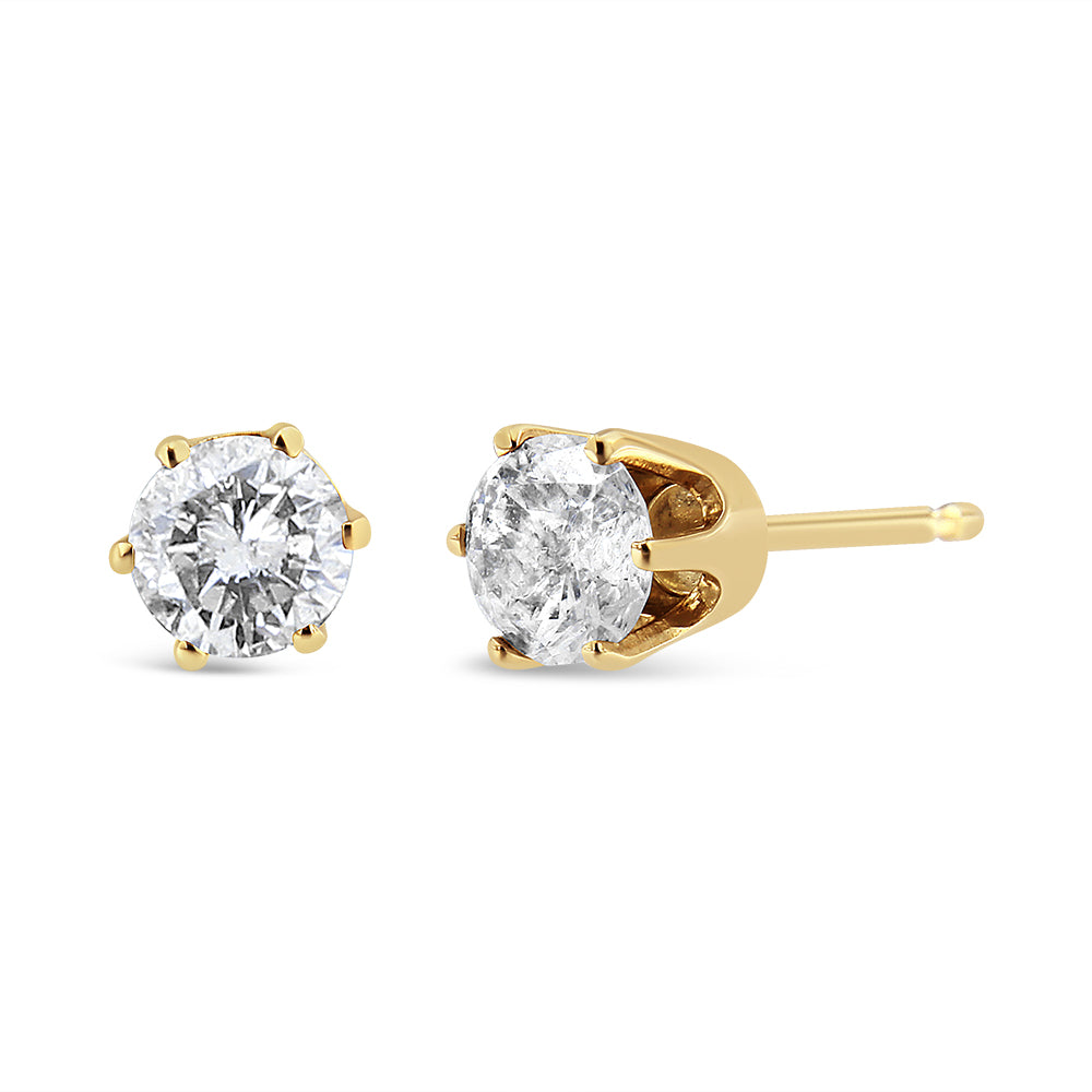 Pair of yellow metal stud earrings with round white gemstones in prong settings, shown at a slight angle on a white background.