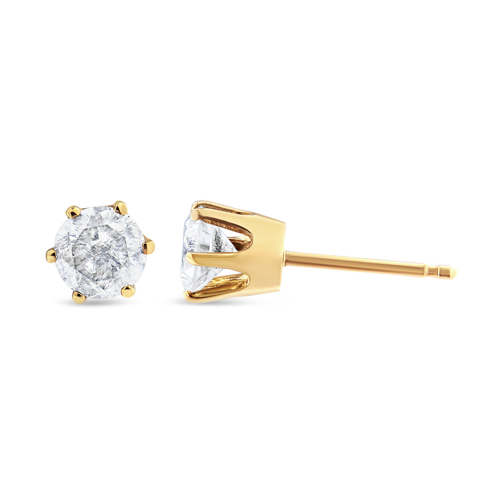 Close-up side and front view of yellow metal stud earrings with round white gemstones in prong settings.