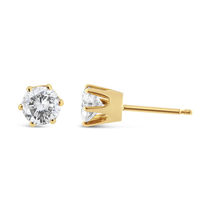 Close-up front and side angle of yellow metal stud earrings with round white gemstones in prong settings.