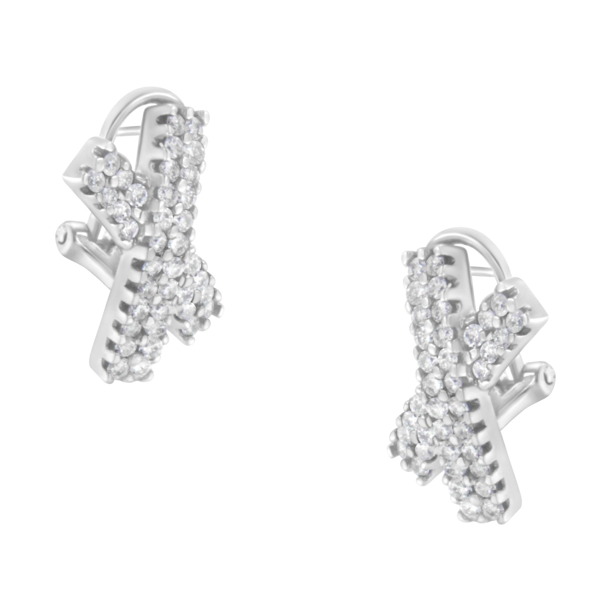 Close-up front angle of white metal X-shaped earrings adorned with multiple small round white gemstones in prong settings.