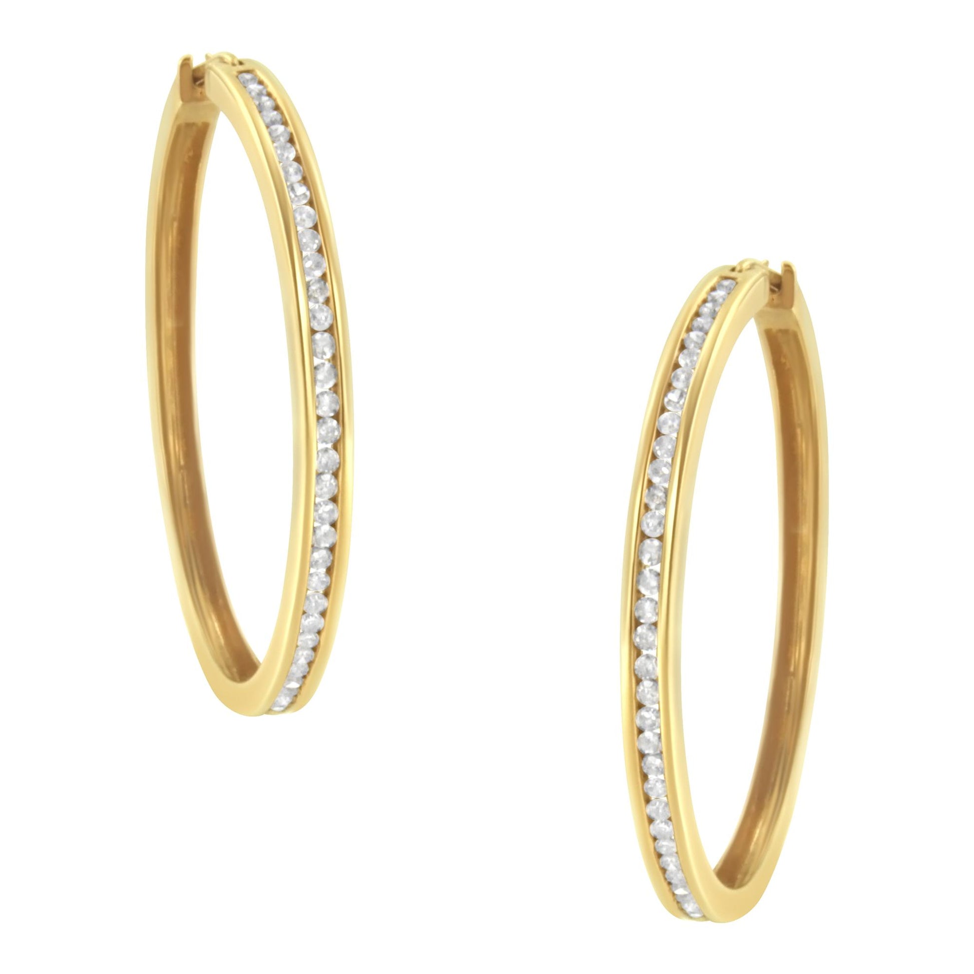 Pair of yellow metal hoop earrings with round white gemstones set in a channel along the front, shown from a slightly angled front view.