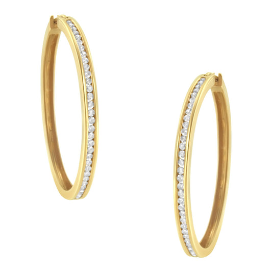 Pair of yellow metal hoop earrings with round white gemstones set in a channel along the front, shown from a slightly angled front view.