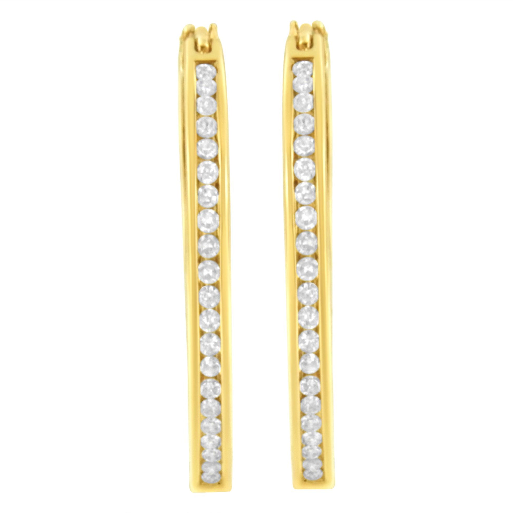 Front view of a pair of yellow metal earrings with a vertical row of round white gemstones in channel settings.