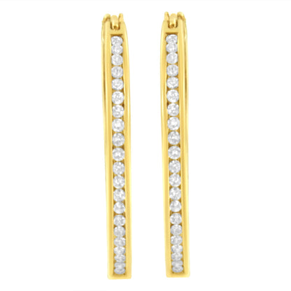 Front view of a pair of yellow metal earrings with a vertical row of round white gemstones in channel settings.