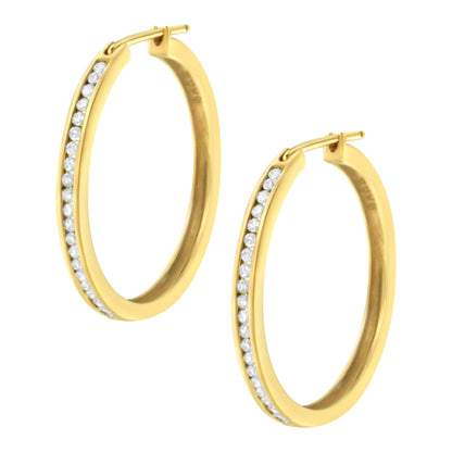 Pair of yellow metal hoop earrings viewed from an angled front perspective, each featuring a channel setting of round white gemstones along the outer edge.