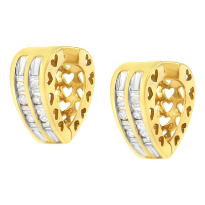 Pair of yellow metal heart-shaped earrings with cut-out heart patterns on the inner side and two rows of channel-set white round and baguette gemstones on the outer side, shown from a slight angle.