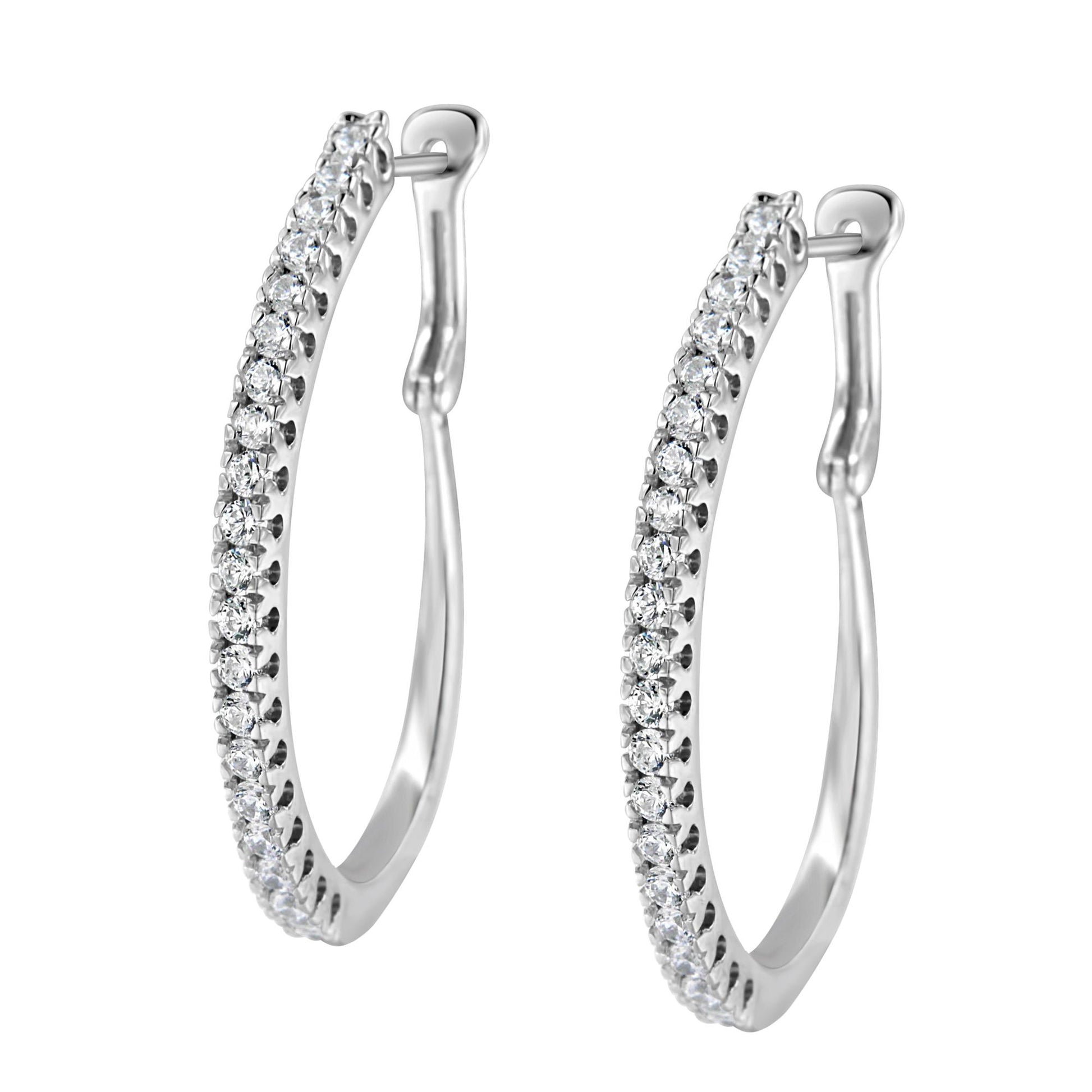 Pair of white metal earrings in a partial hoop shape, set with round white gemstones in a pave setting, shown from a front angle.