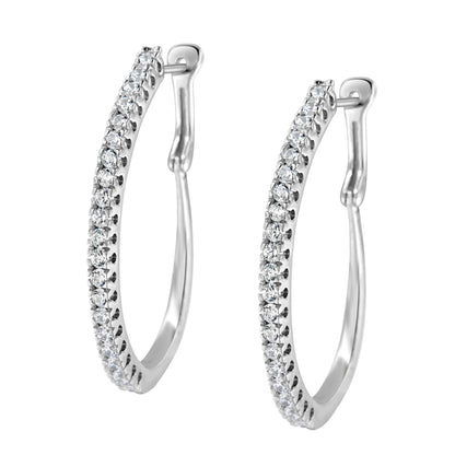 Pair of white metal earrings in a partial hoop shape, set with round white gemstones in a pave setting, shown from a front angle.