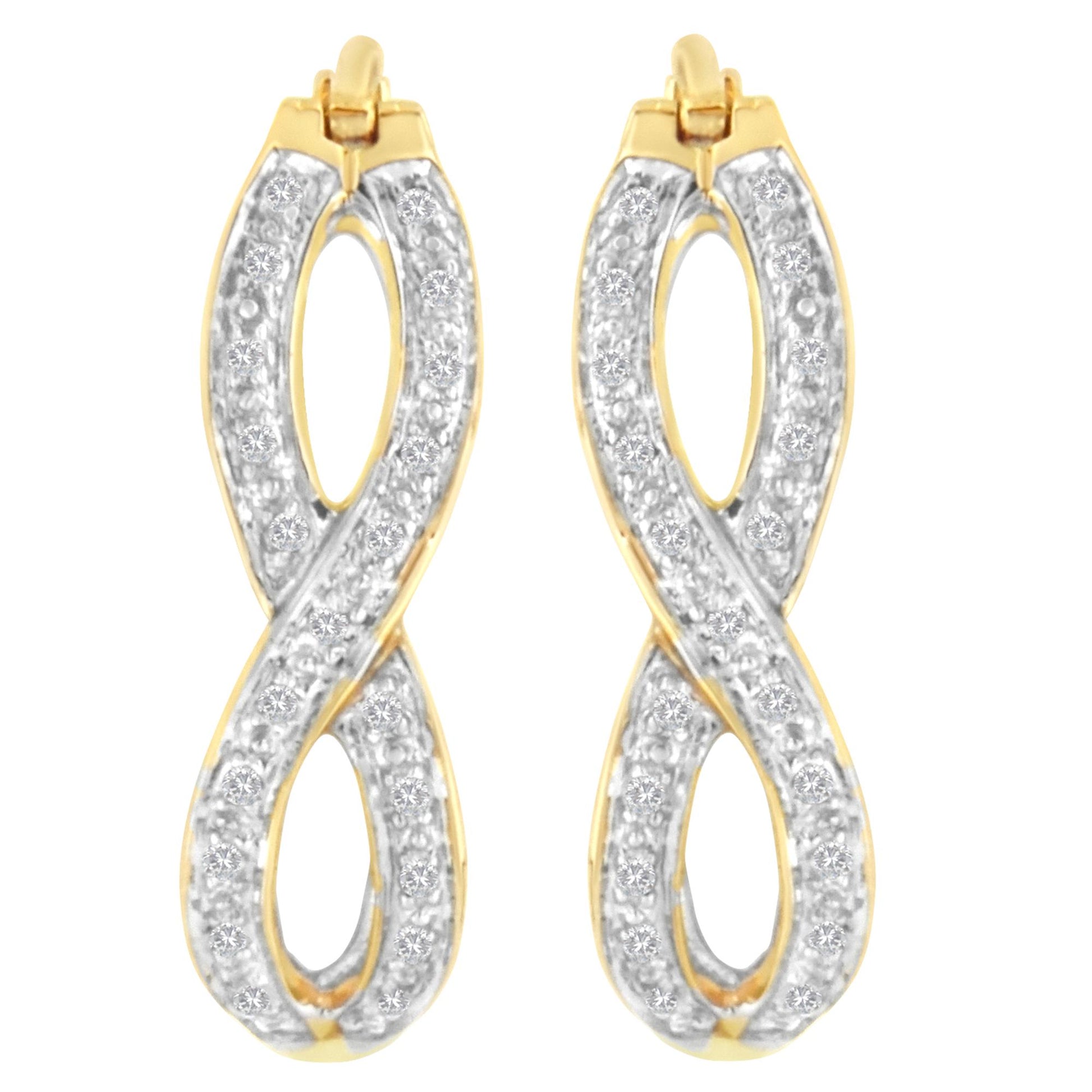 Front view of a pair of yellow metal earrings shaped in an infinity-like loop, each adorned with multiple white round gemstones in prong settings.