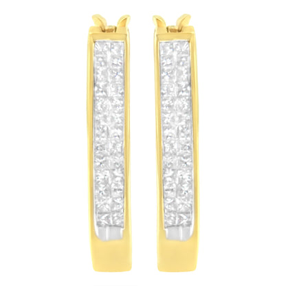 Front-facing close-up of pair of yellow metal hoop earrings with rows of white princess shape gemstones set invisibly along the front surface.