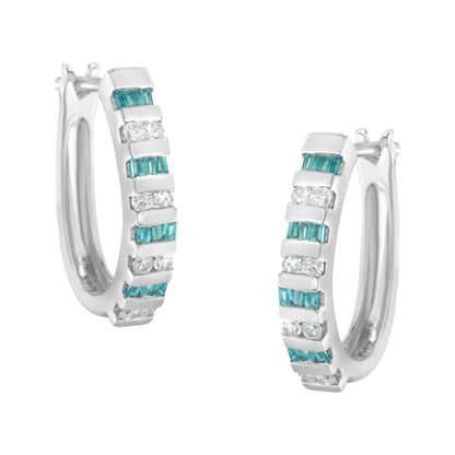 Pair of white metal hoop earrings with alternating rows of blue baguette-shaped gemstones and white round-shaped gemstones in channel settings, shown from a front angle.