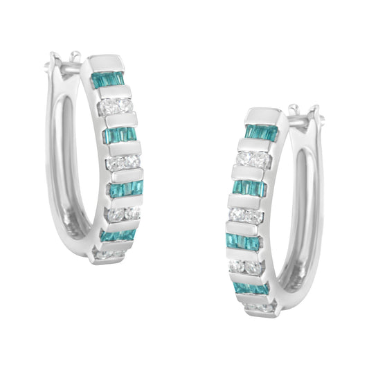 Pair of white metal hoop earrings with alternating rows of blue baguette-shaped gemstones and white round-shaped gemstones in channel settings, shown from a front angle.