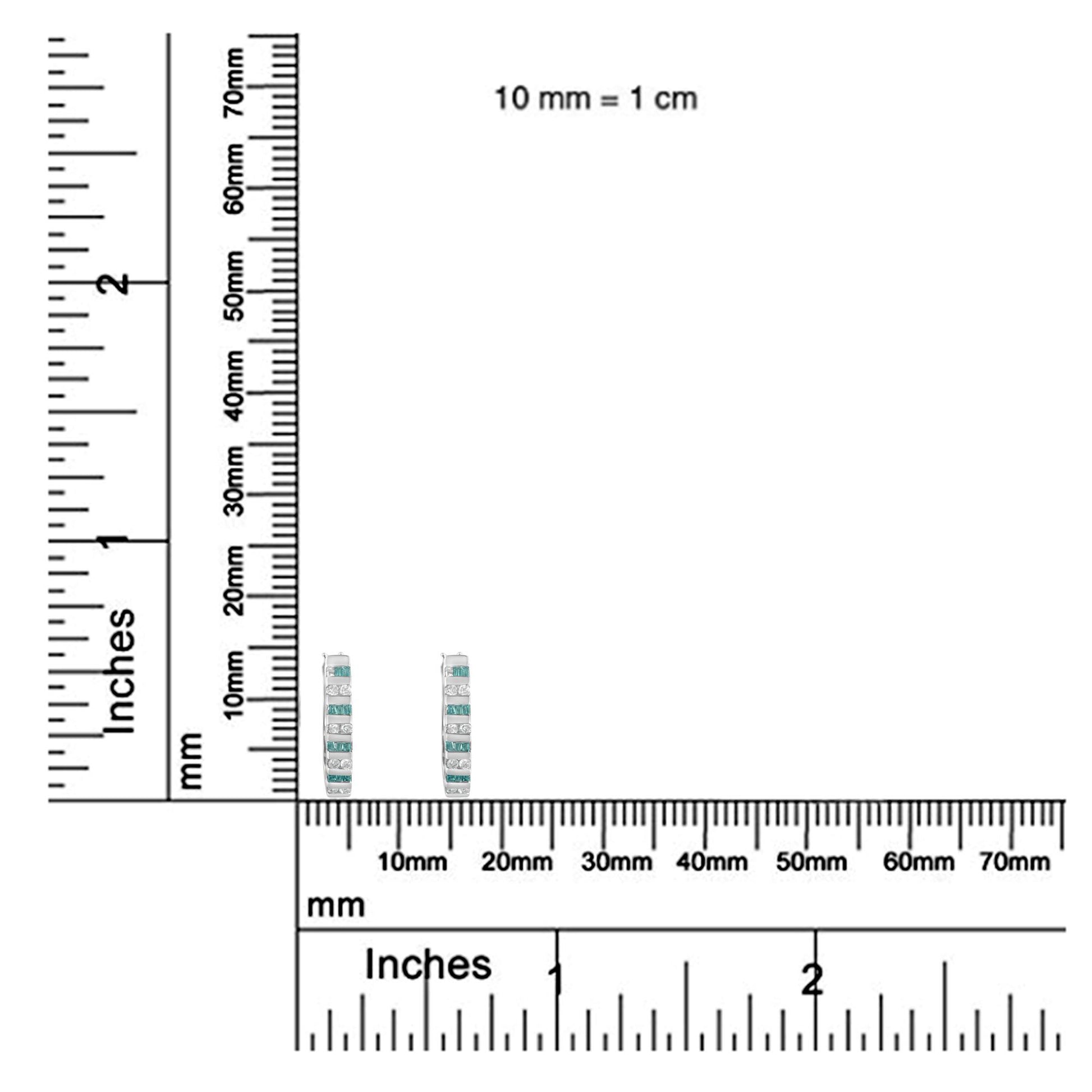 Pair of white metal earrings with alternating rows of channel-set white round and blue baguette gemstones, shown upright on a ruler for size reference.