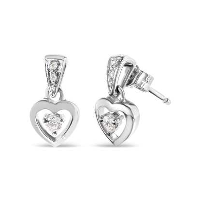 Pair of white metal heart-shaped earrings with white round gemstones in prong settings, shown from front and angled side on a white background.