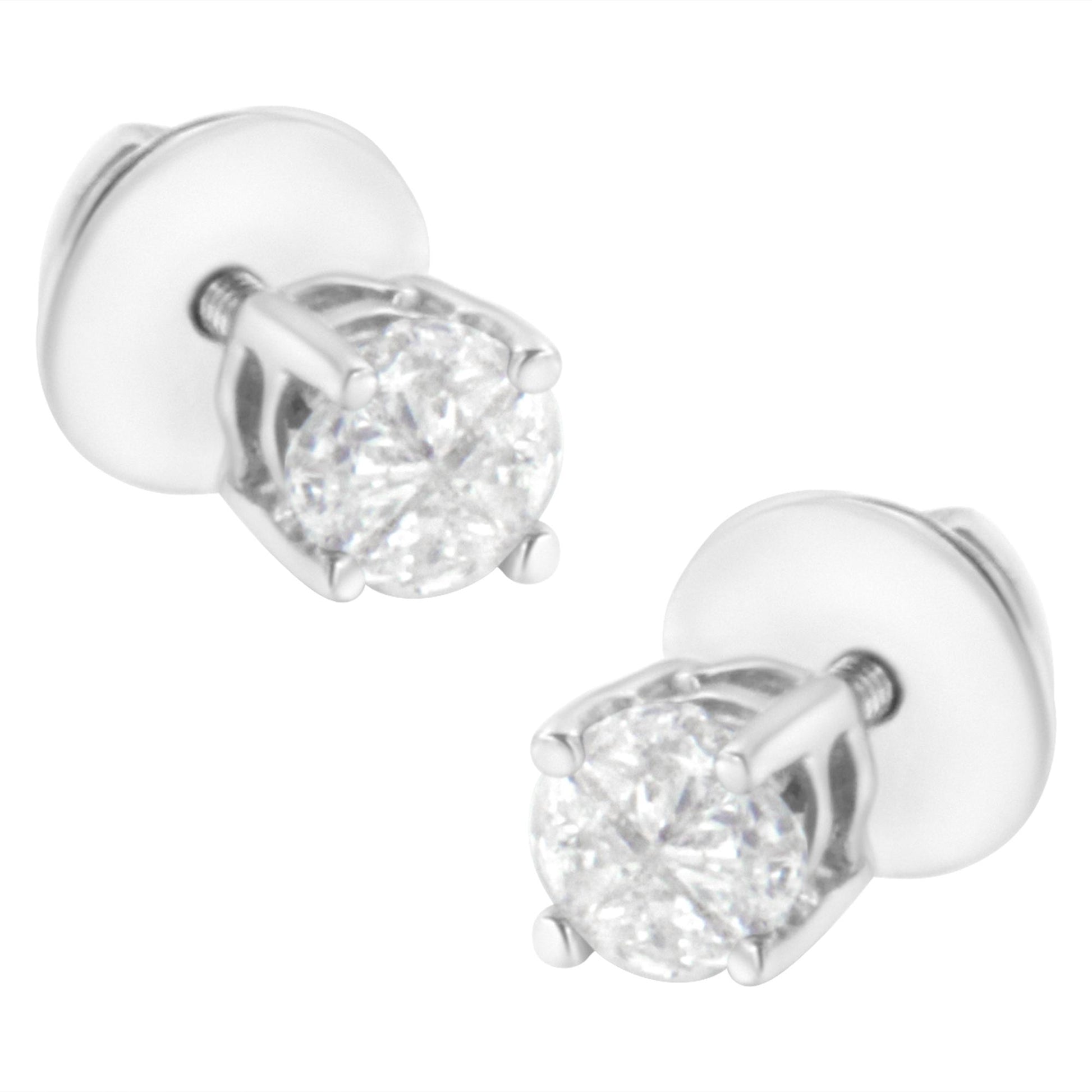 Pair of white metal stud earrings with round white gemstones in prong settings, shown at a slight angle.