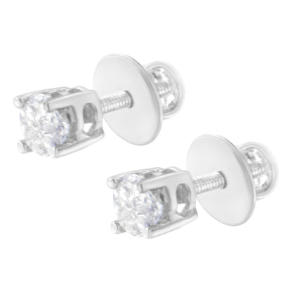 Pair of white metal stud earrings with prong-set white pie-shaped gemstones, shown in close-up angled view.