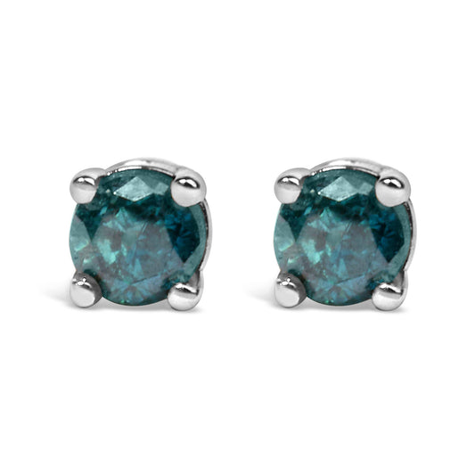 Front angled view of white metal stud earrings each set with a round blue gemstone in a prong setting.