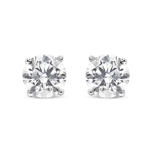 Front-facing view of a pair of white metal stud earrings featuring round white gemstones in prong settings.