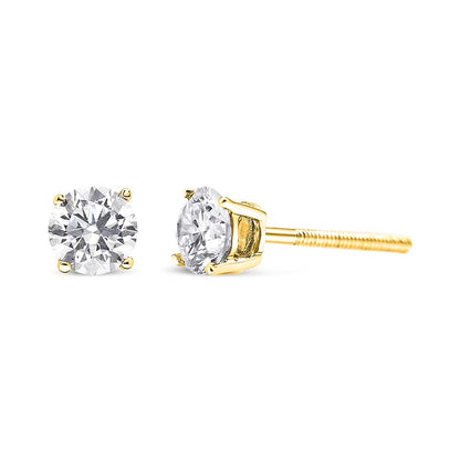 Close-up front and side view of a pair of yellow metal stud earrings with round white gemstones in prong settings.