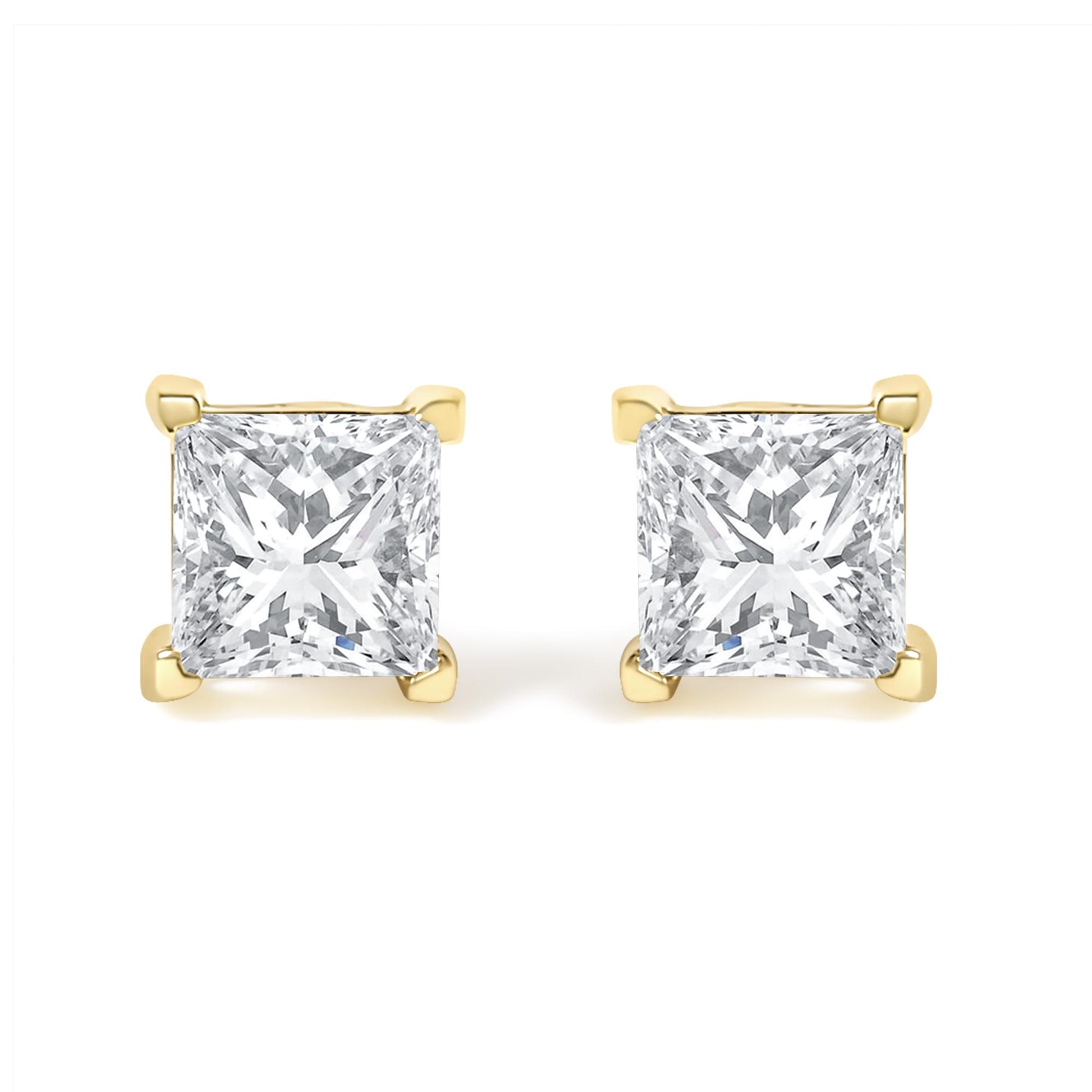 Front view of a pair of yellow metal stud earrings each featuring a princess-shaped white gemstone in a four-prong setting.