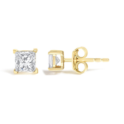 Pair of yellow metal stud earrings with princess shape white gemstones in four-prong settings shown from front and side angles.