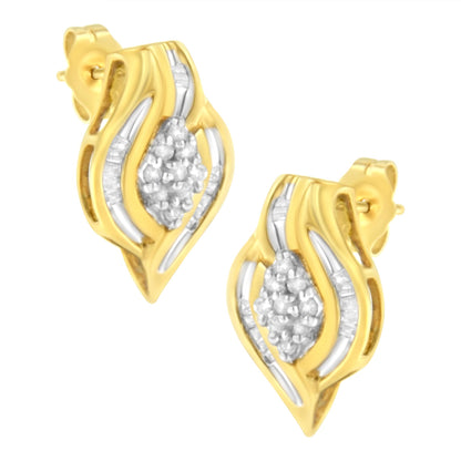 Pair of yellow metal earrings with a wavy design, featuring clustered round white gemstones in prong settings at the center and baguette white gemstones in channel settings along the sides, shown in a front angled view.