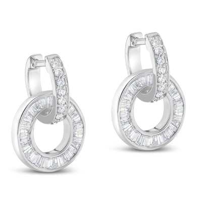 Pair of white metal earrings shown at a slight angle, each featuring a hoop with channel-set baguette white gemstones and a curved top section adorned with prong-set round white gemstones.