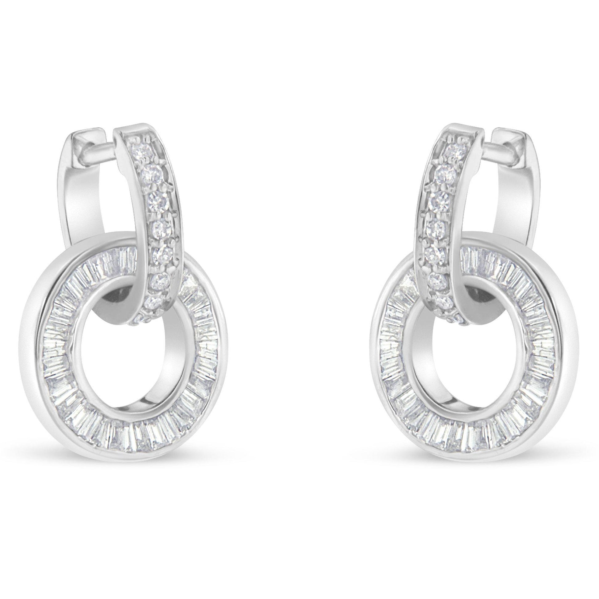 Pair of white metal earrings with a circular hoop design featuring channel-set baguette-shaped white gemstones and a row of prong-set round white gemstones on the top hoop, shown from the front angle.