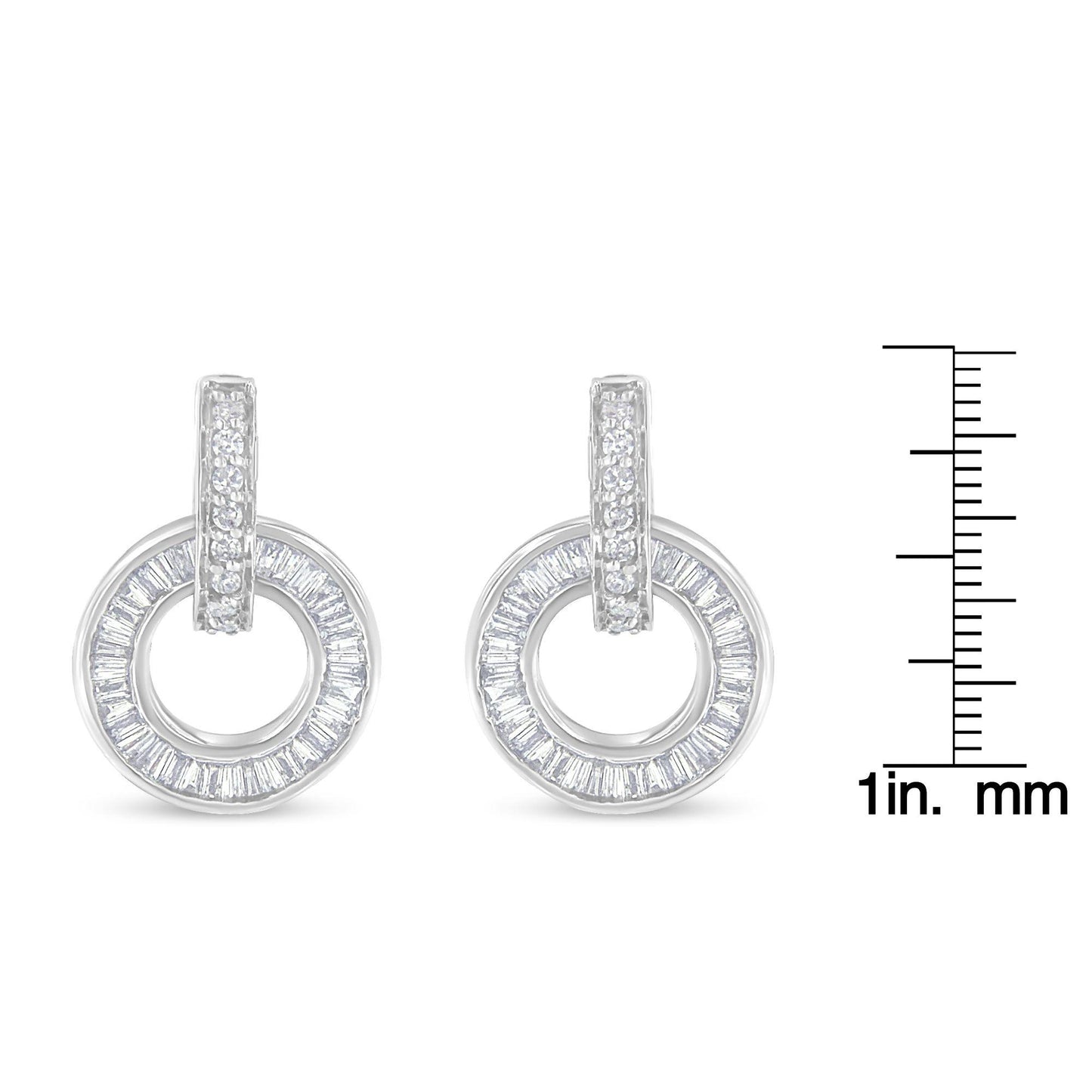 Front-facing view of white metal circular earrings with a row of round white gemstones set on the vertical bar and baguette-shaped white gemstones arranged in a circle, displayed next to a ruler for size reference.