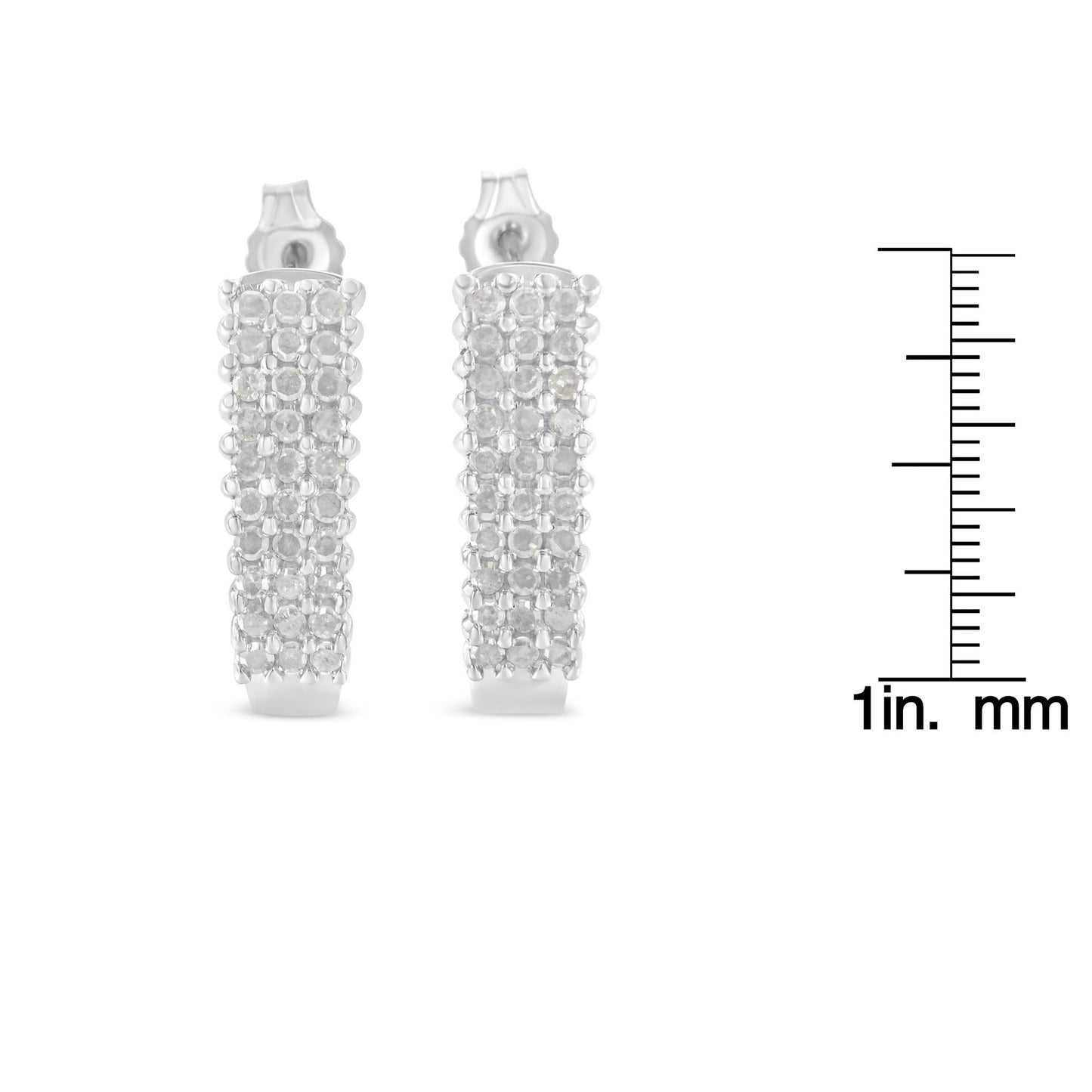 Pair of white metal earrings with multiple rows of round white gemstones in prong settings, front view, shown with a ruler for size reference.