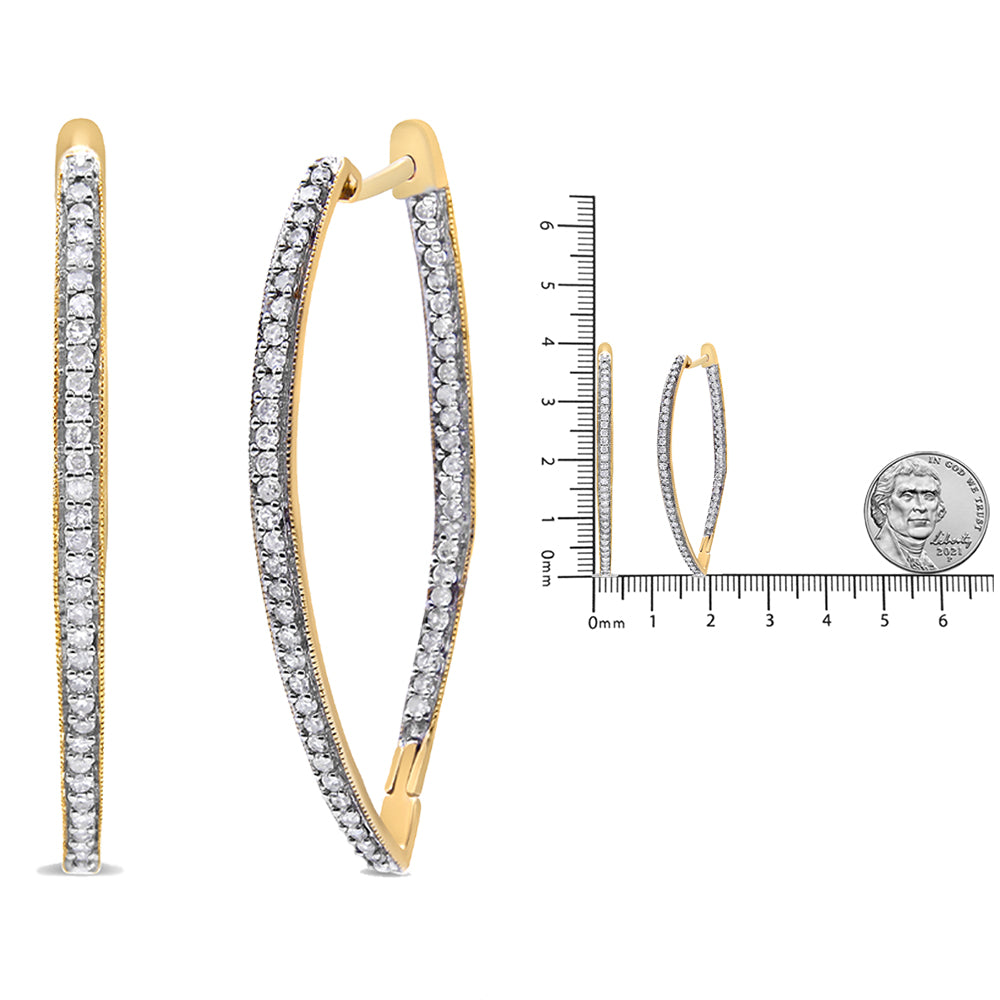 Front and side view of elongated yellow metal hoop earrings with white round gemstones in prong settings, shown on a ruler for size reference.