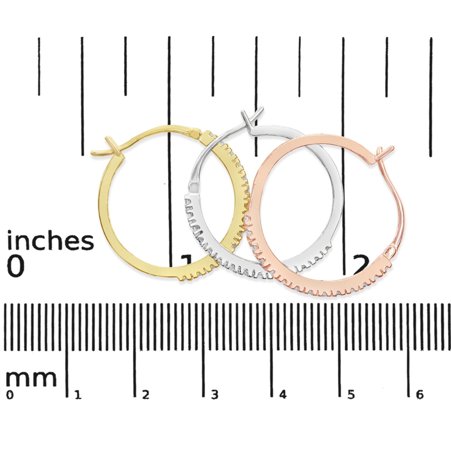 Top-down view of three small hoop earrings in yellow, white, and rose metal colors, set with white round prong-set gemstones, displayed on a ruler for size reference.