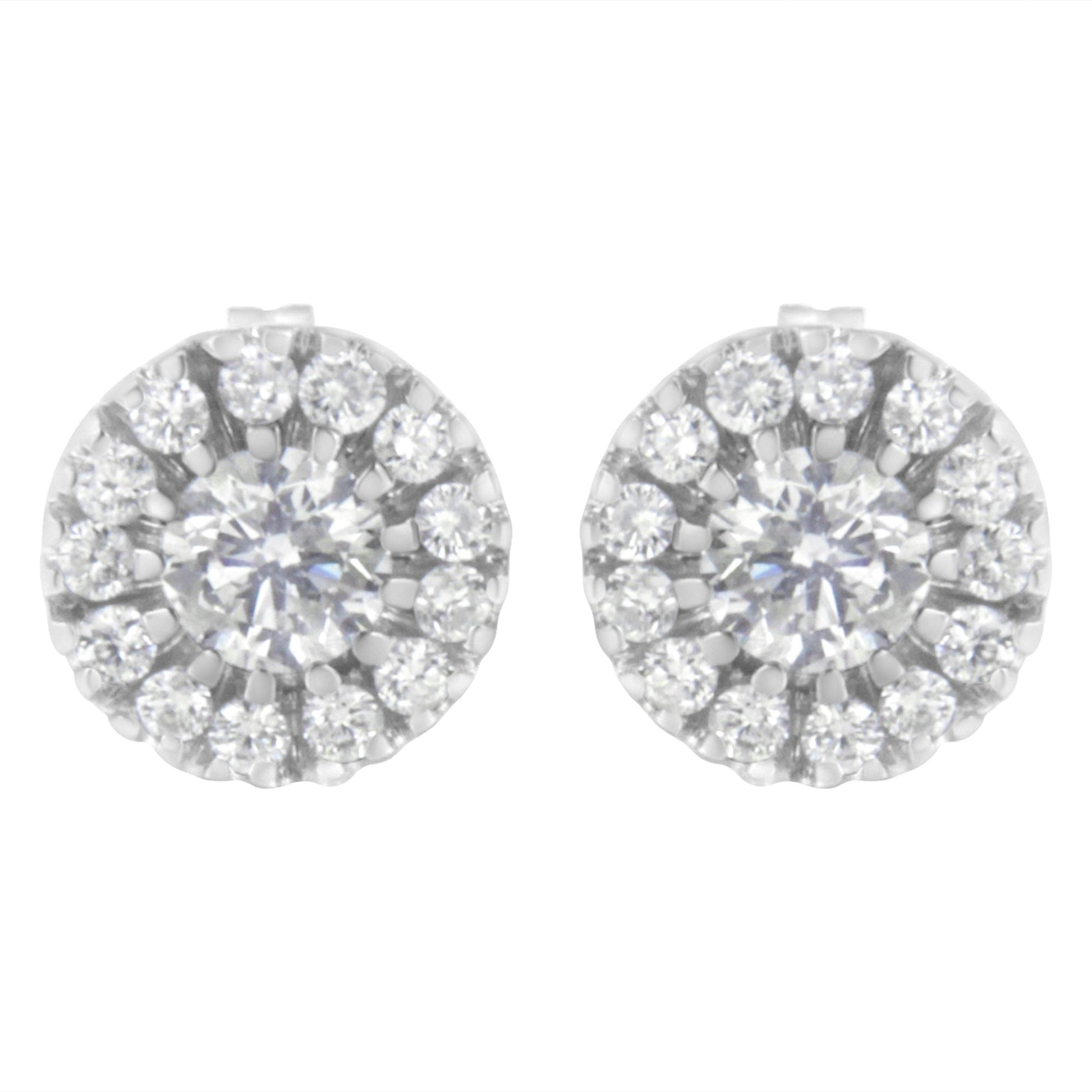 Front view of white metal round stud earrings featuring a central round white gemstone in prong setting surrounded by smaller round white gemstones in pave setting.