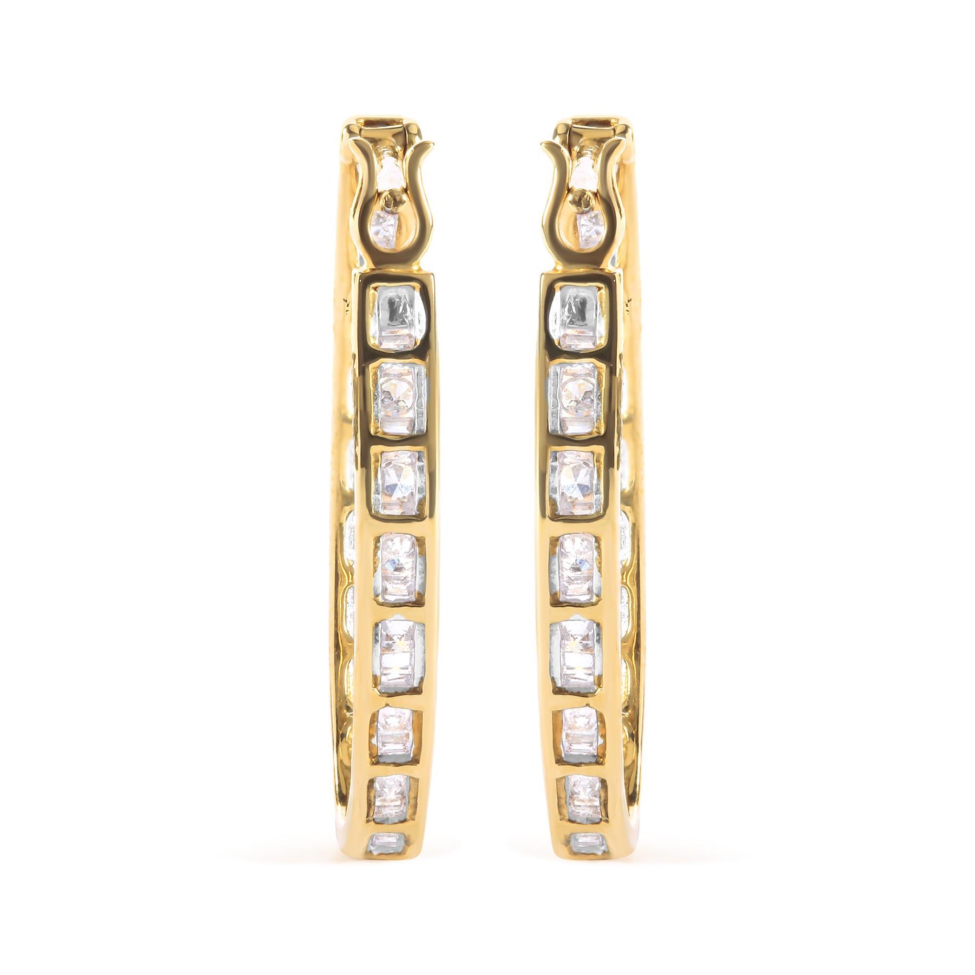 Front view of yellow metal hoop earrings with channel-set white baguette gemstones and prong-set round white gemstones.