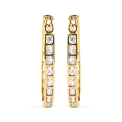 Front view of yellow metal hoop earrings with channel-set white baguette gemstones and prong-set round white gemstones.