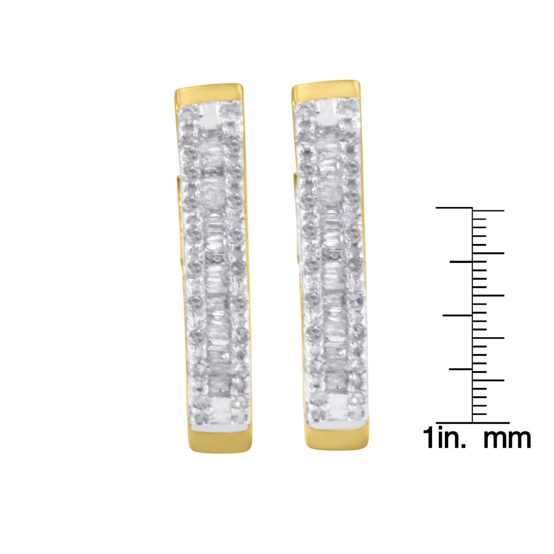 Front view of a pair of yellow metal earrings with rows of white round gemstones in prong settings and white baguette gemstones in channel settings, shown next to a ruler for size reference.